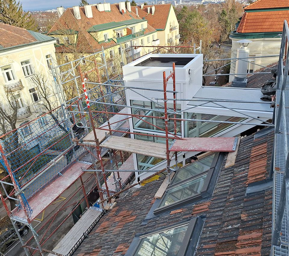 Verglaster Au&szlig;enaufzug w&auml;hrend der Montage auf dem Dach eines Geb&auml;udes in Wien.
