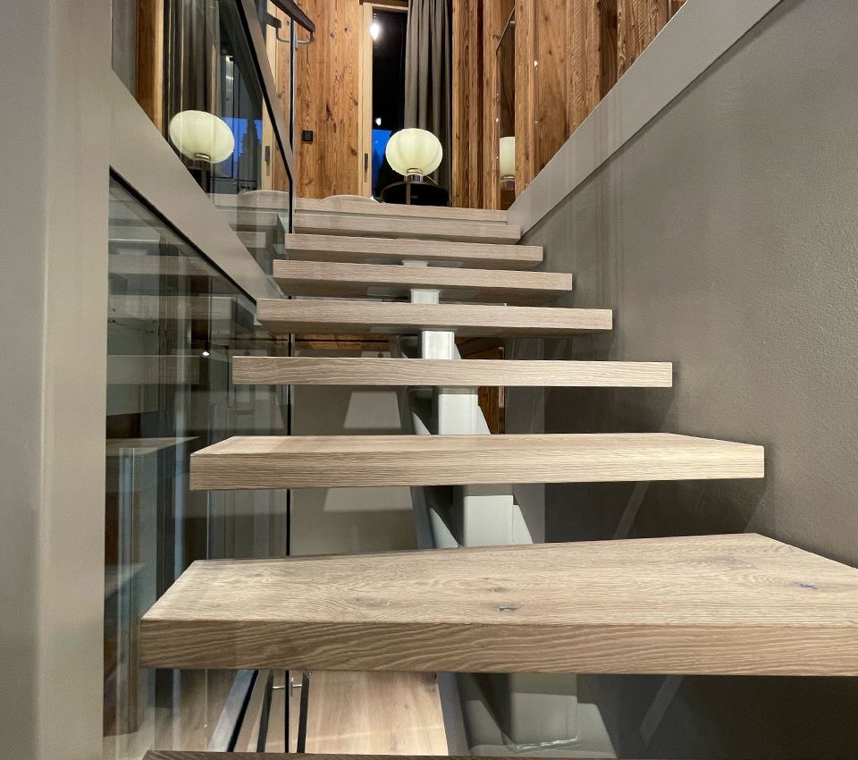 Offene Holztreppe neben dem verglasten Homelift im Projekt Heritage in Aurach.