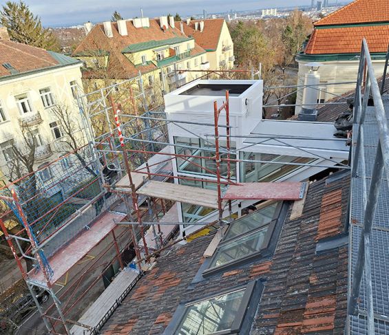 Verglaster Au&szlig;enaufzug w&auml;hrend der Montage auf dem Dach eines Geb&auml;udes in Wien.