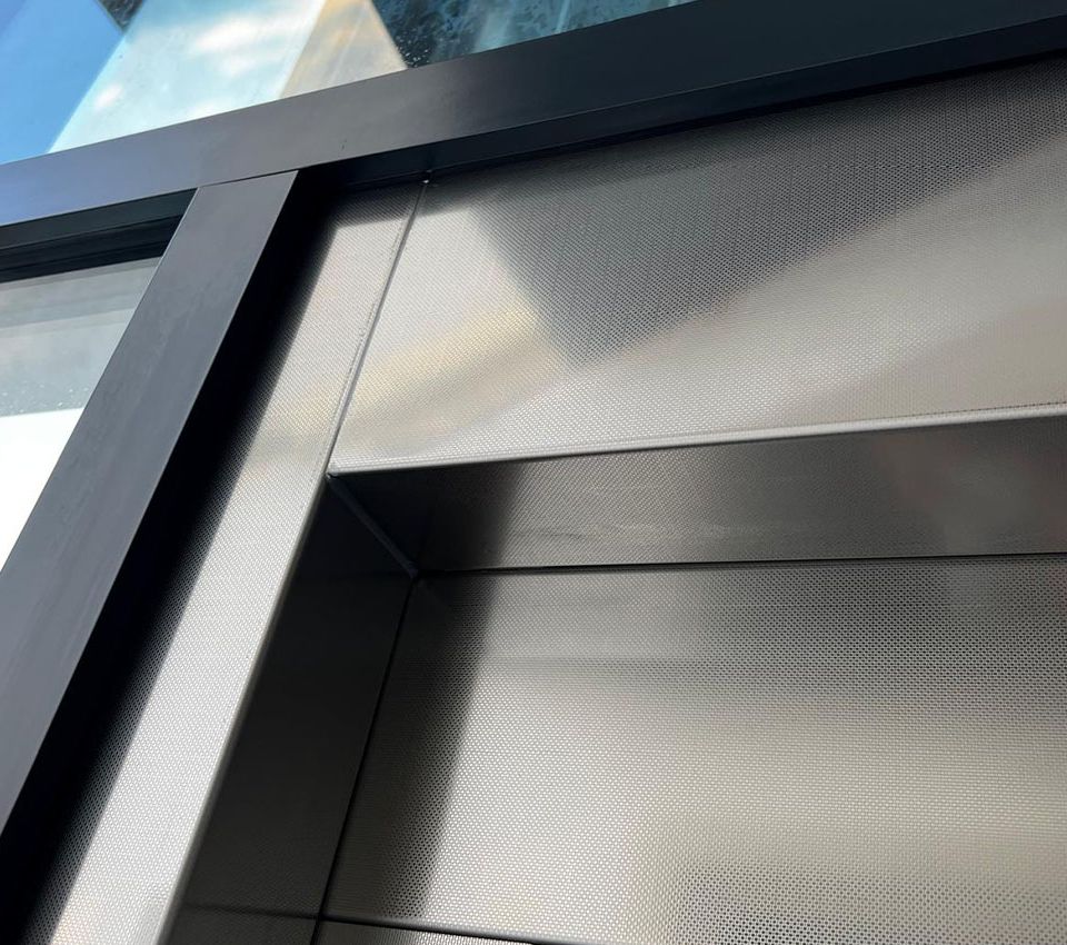 Detailansicht der Metallverkleidung und Glaskonstruktion des Aufzugsschachts.